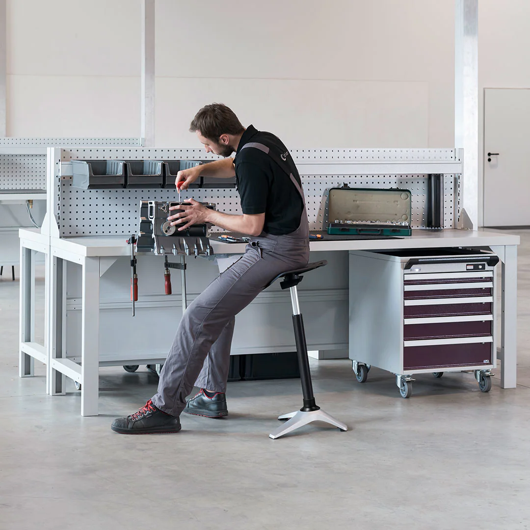 Detailansicht der ergonomischen Sattelsitz-Form und des polierten Aluminium-Fußkreuzes